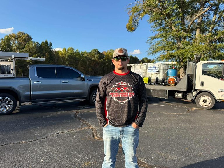 Nick Weaver, owner of Proline Power Wash & Soft Wash LLC, standing in front of his GMC truck and house-washing rig